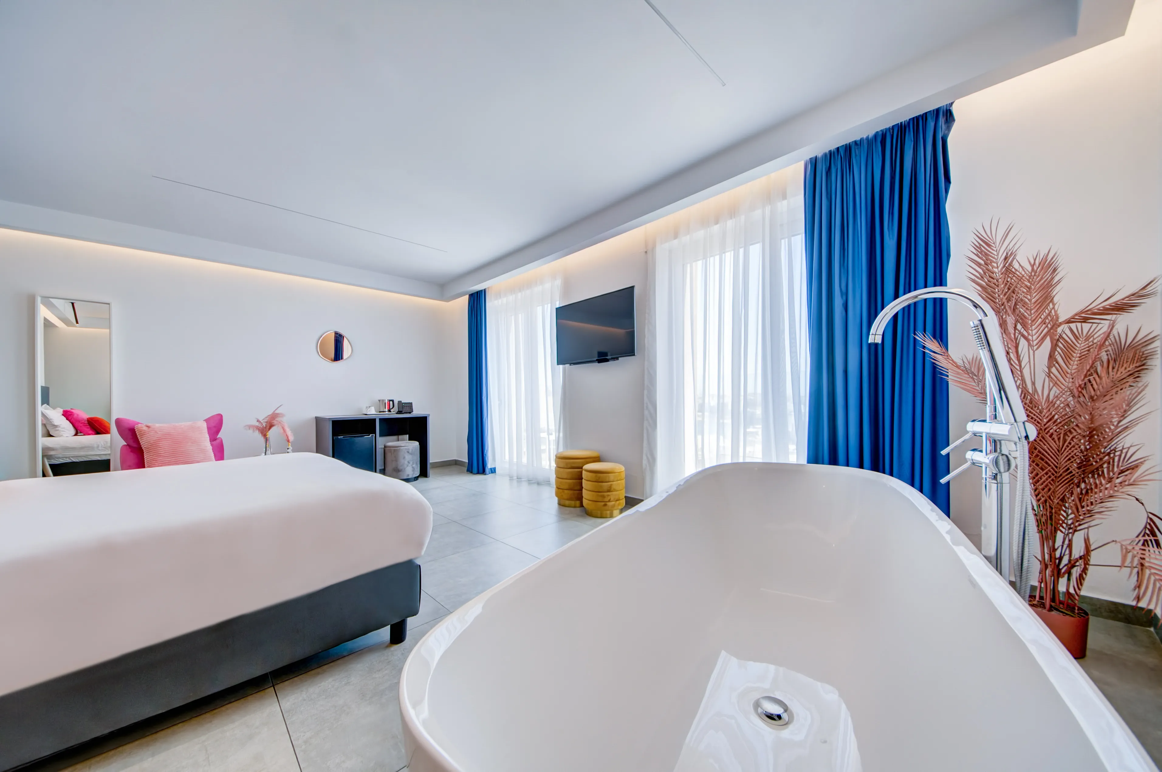 King suite with freestanding bathtub and blue curtains