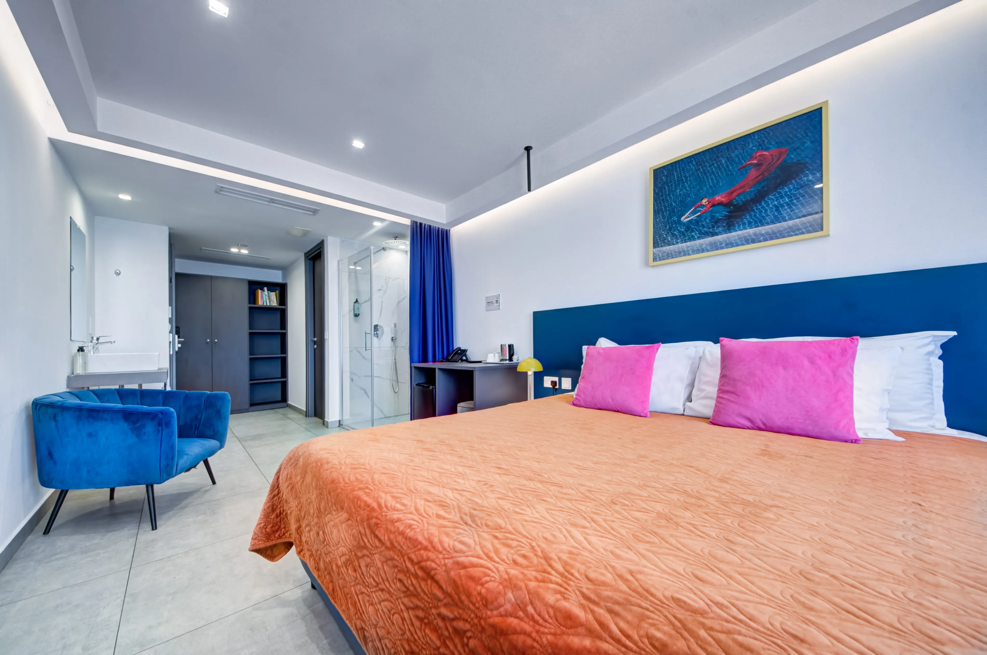 Standard room with blue chair and modern furnishings